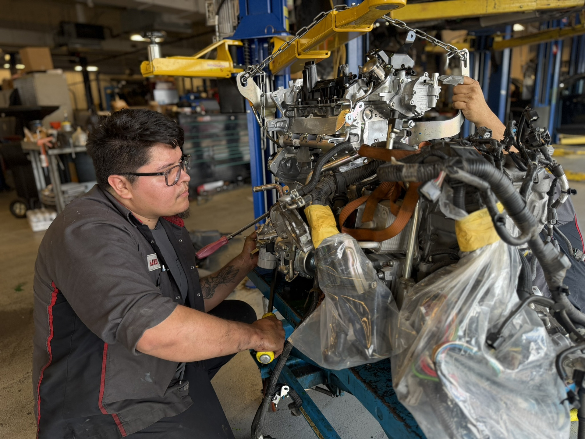 Service tech pouring oil into a vehicle for an oil change