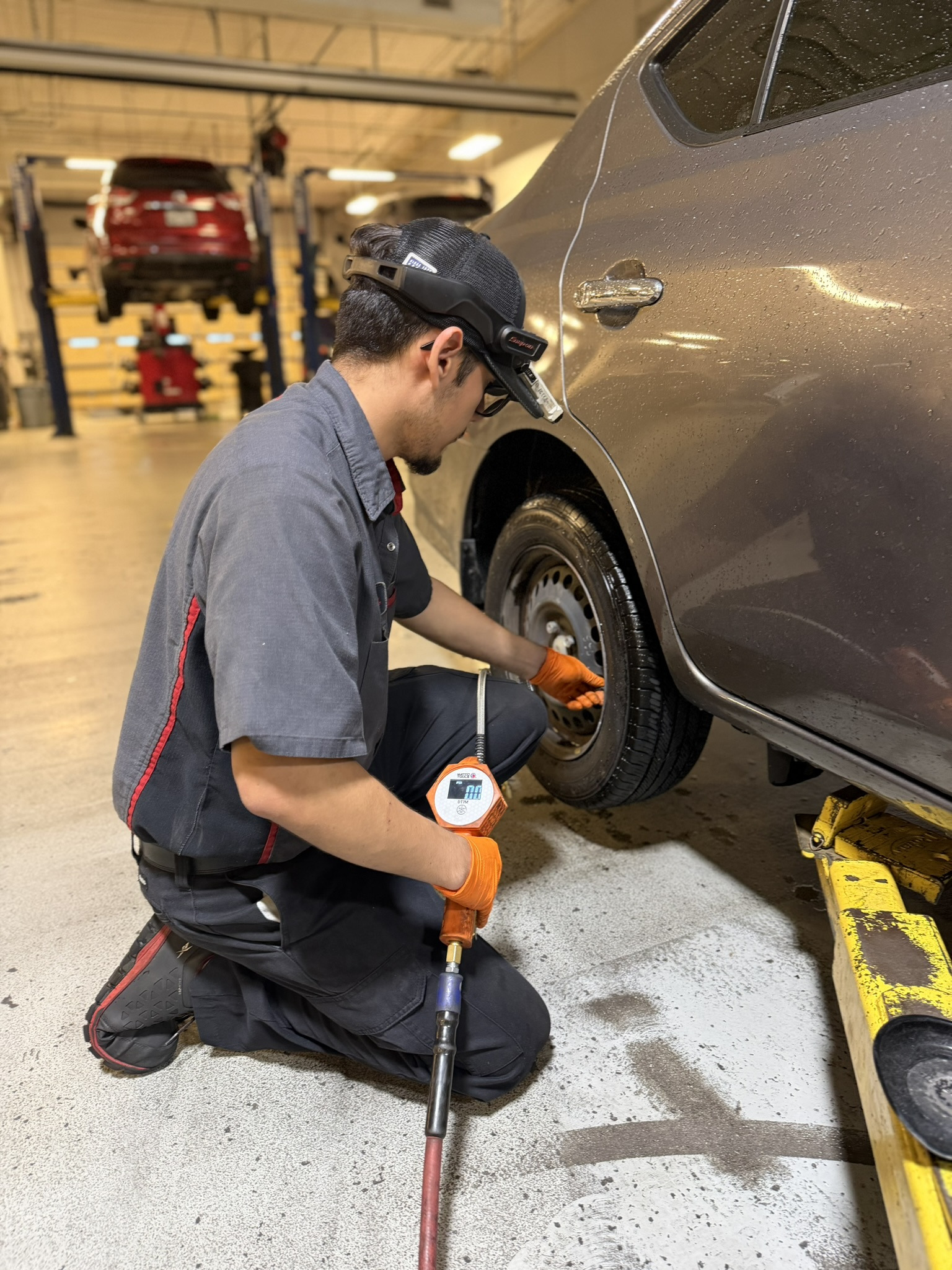 Close up of service tech rolling a tire through the service bay