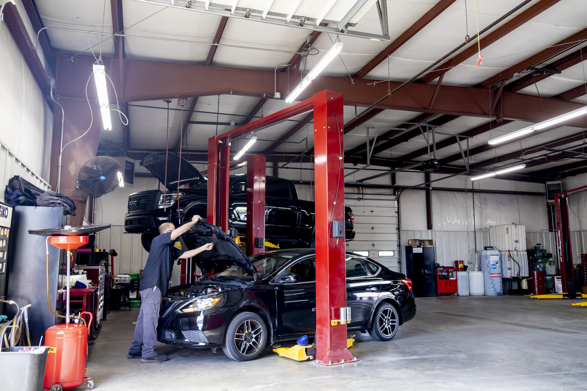 Body shop technician inspecting vehicle panel