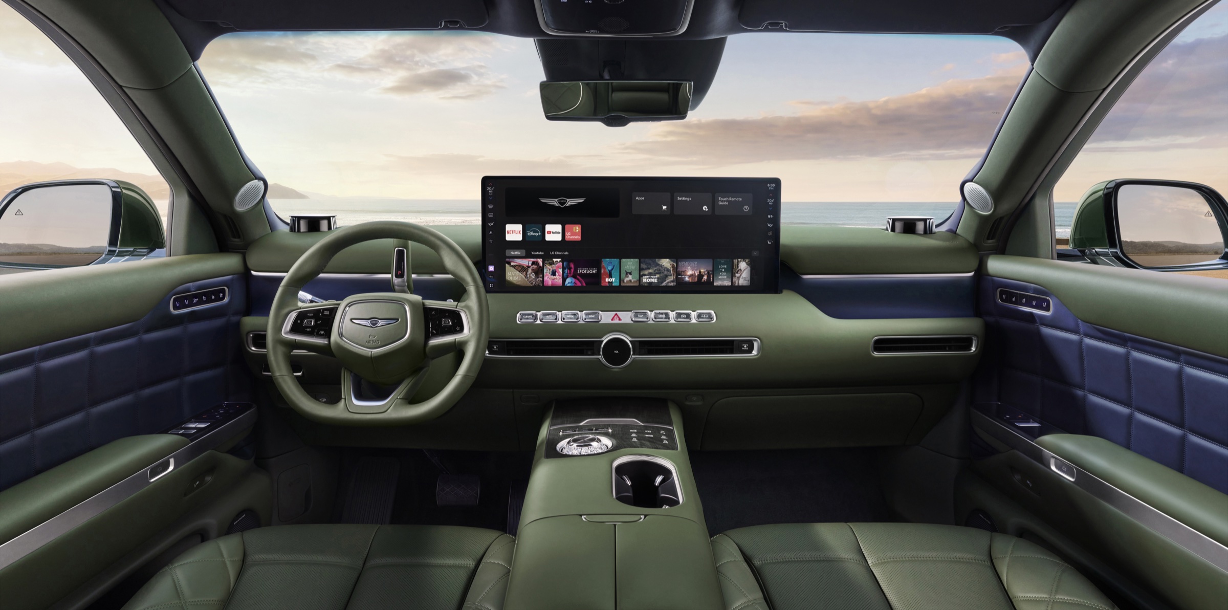 Sage green GV90 cabin facing a wide 24.6-inch display at sunset
