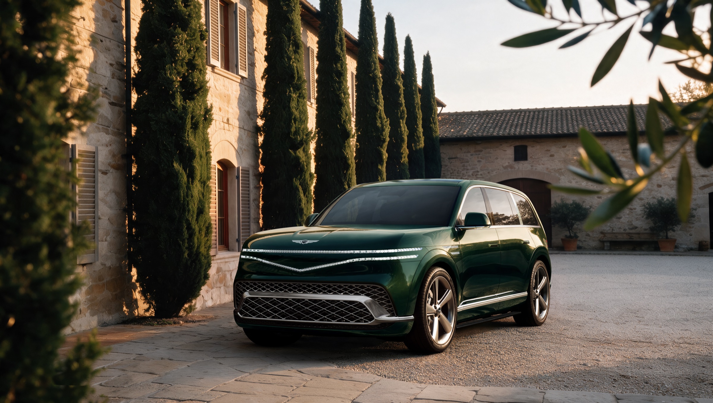 Forest green GV90 on a stone courtyard in front of a villa at golden hour