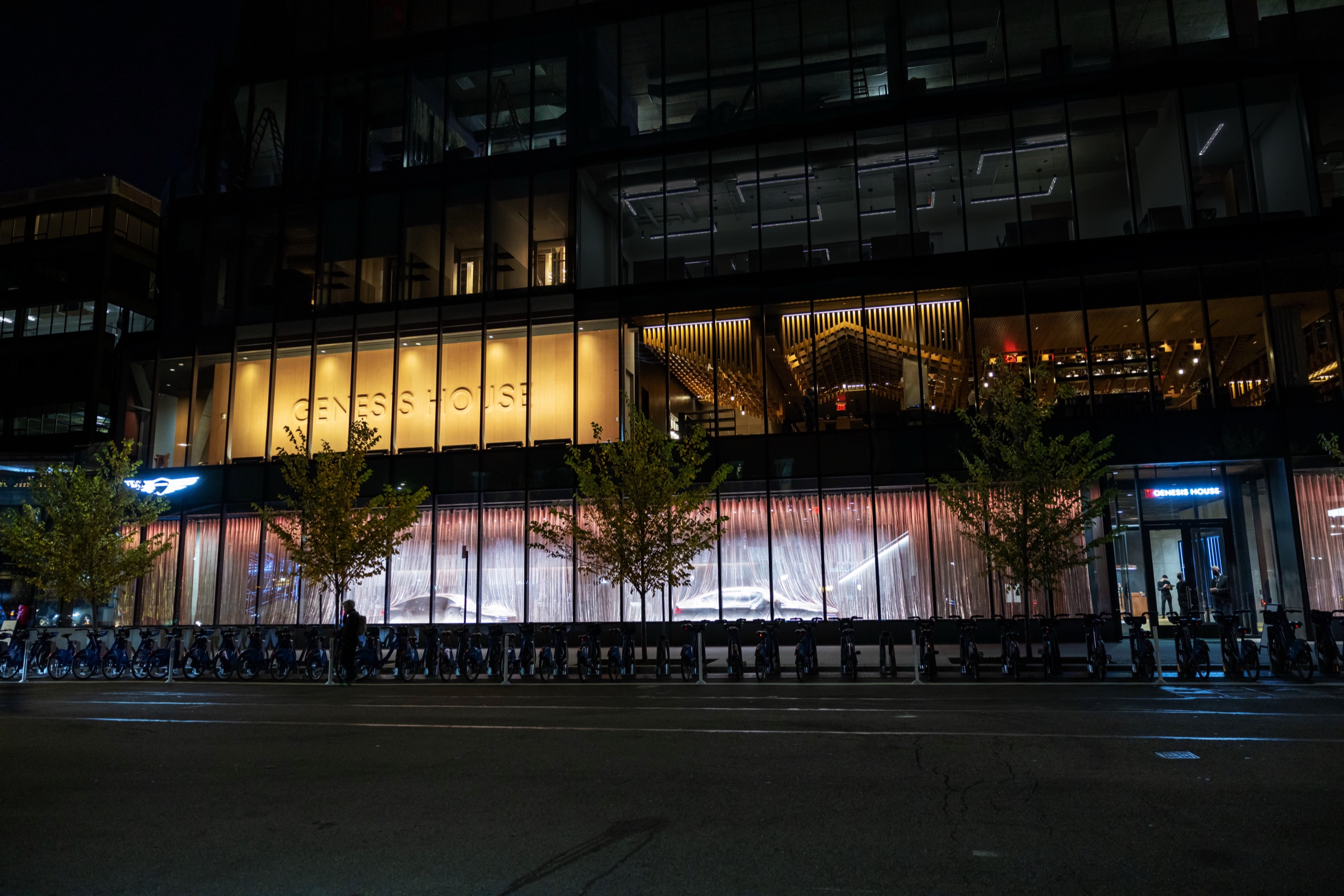 Genesis House in New York City at night, with the illuminated facade and showroom