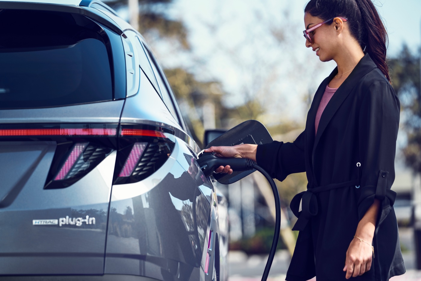 Hand plugging a charging connector into a Hyundai EV