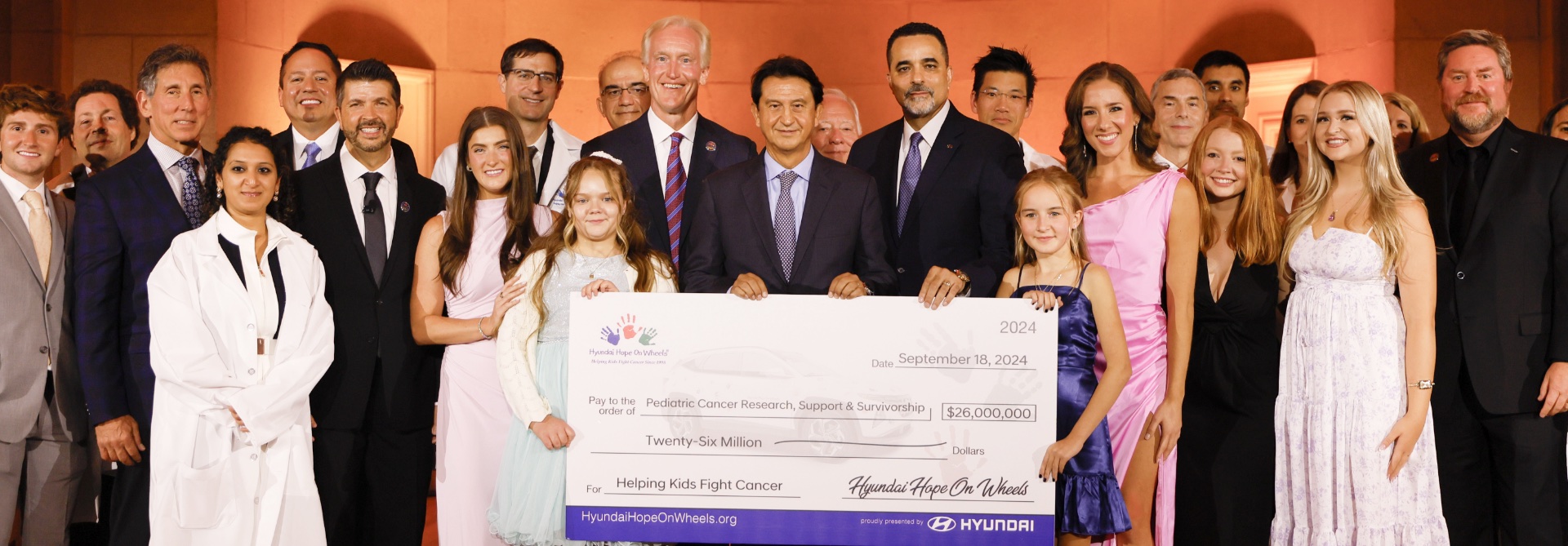 Hyundai Hope on Wheels representatives, doctors, and children presenting a ceremonial research grant check