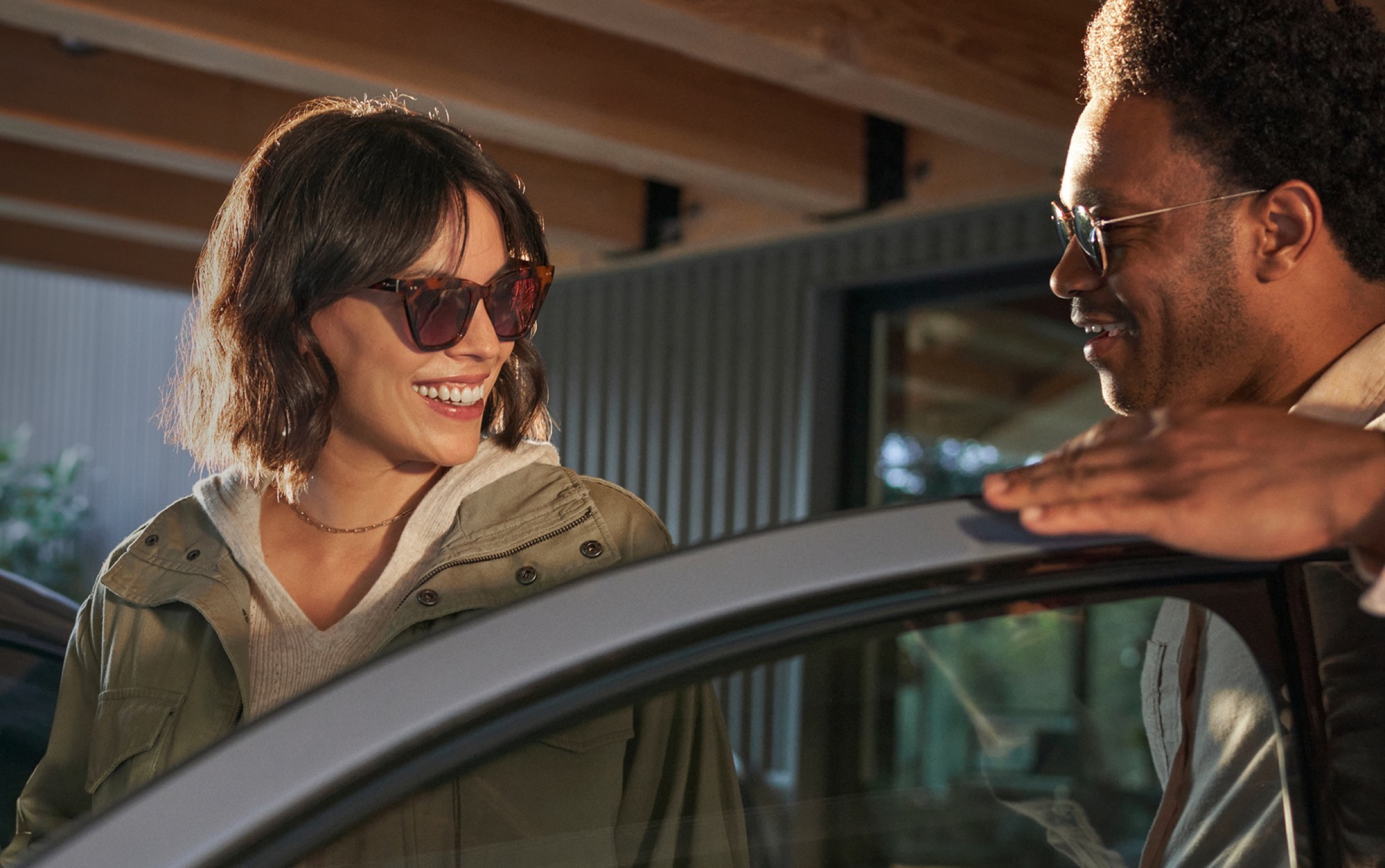 Two people standing beside a Hyundai with the driver door open