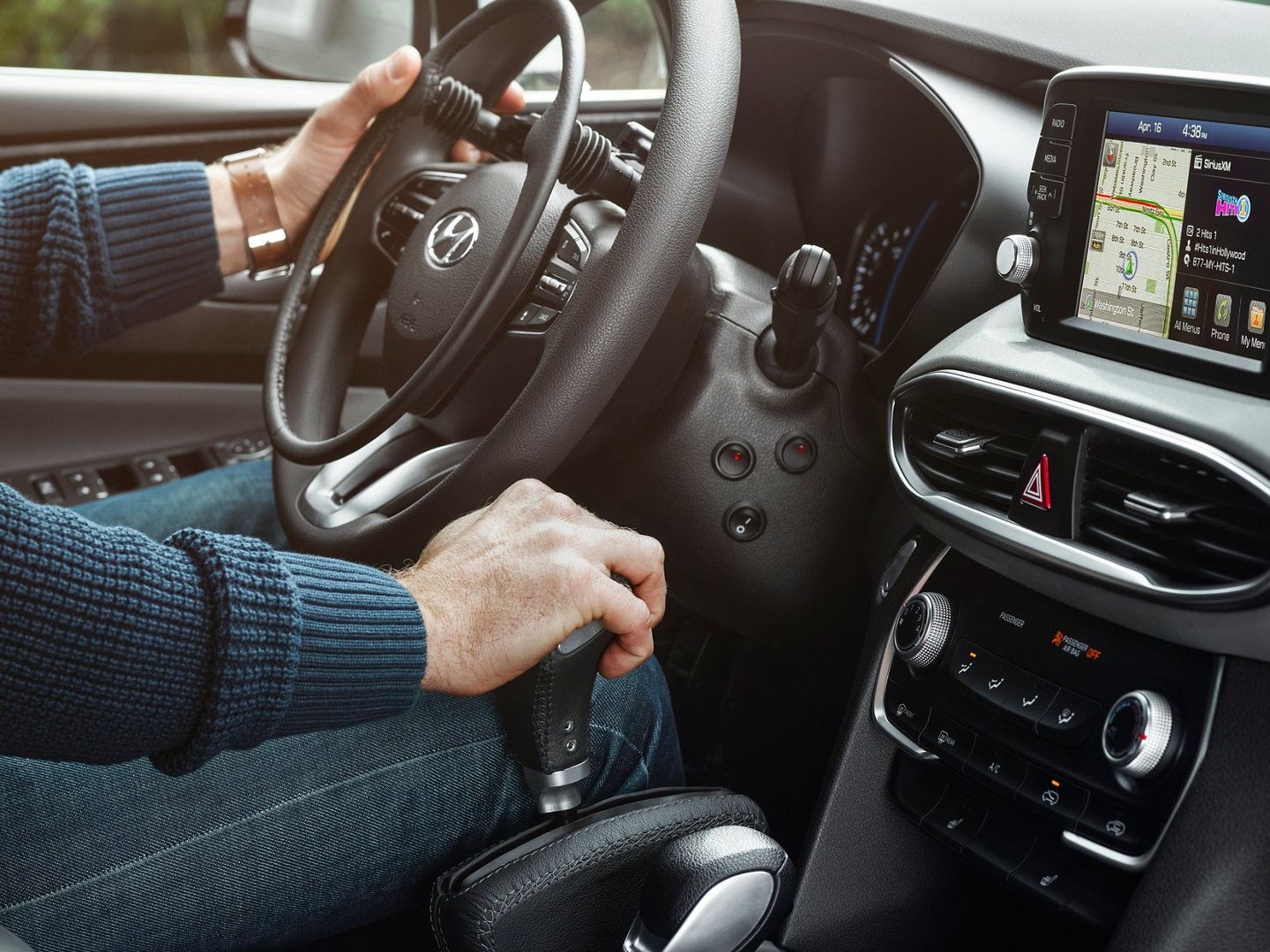 Hyundai driver using a steering-wheel spinner knob and a hand-operated accelerator and brake lever