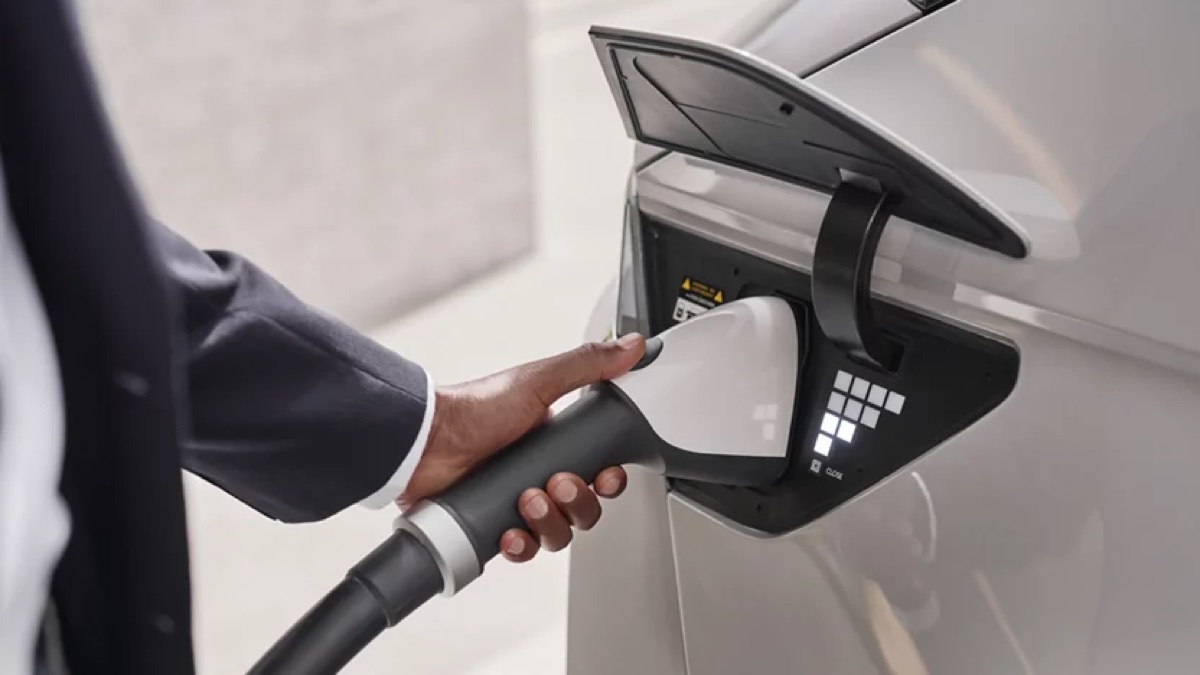 Hand plugging a connector into a Hyundai EV charging port