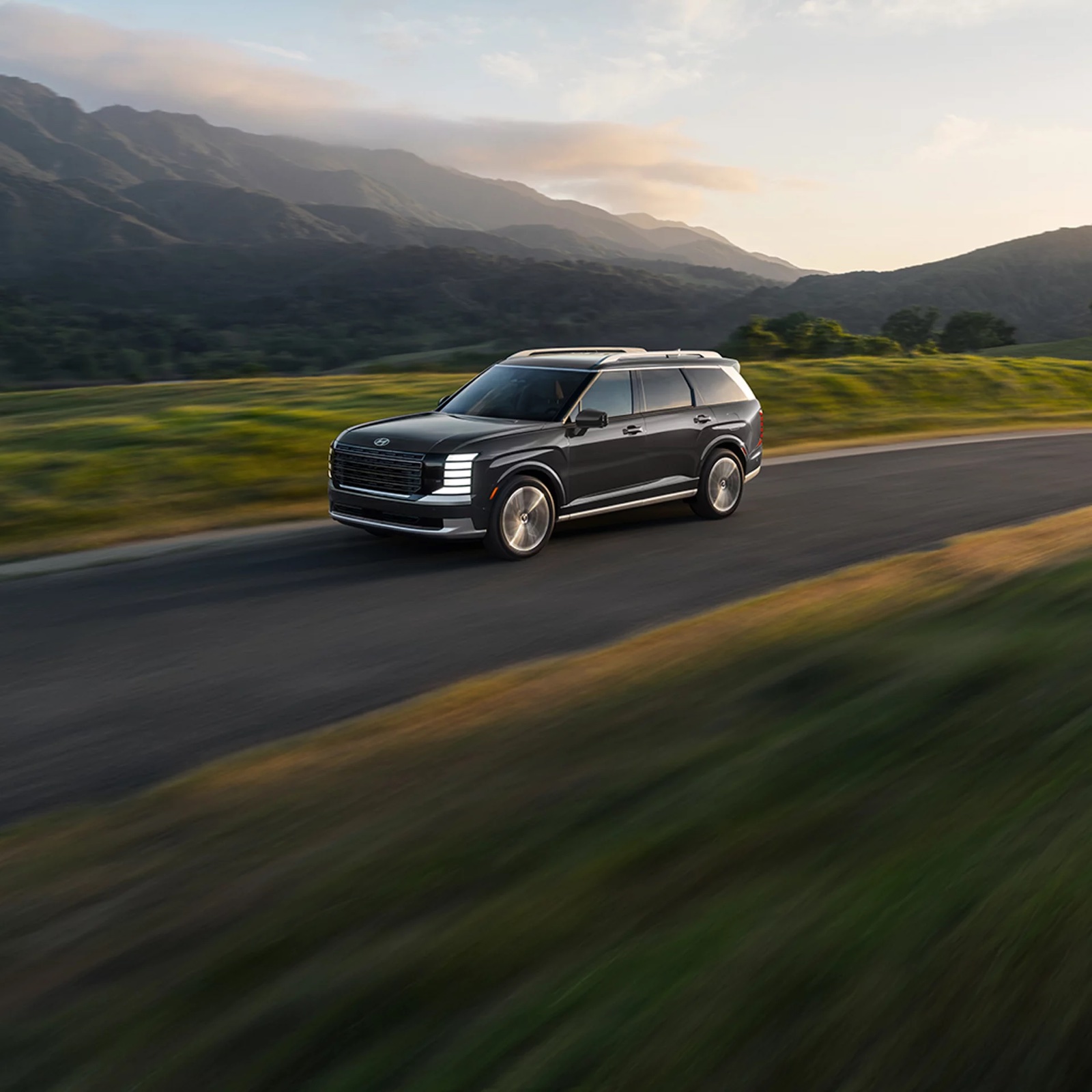 Hyundai PALISADE Hybrid driving through a mountain valley