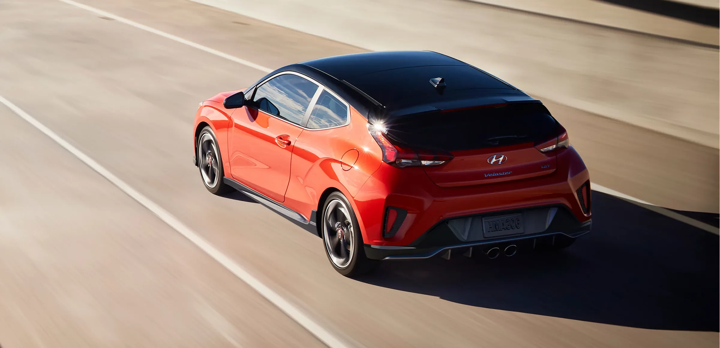 Red Hyundai Veloster driving on a highway