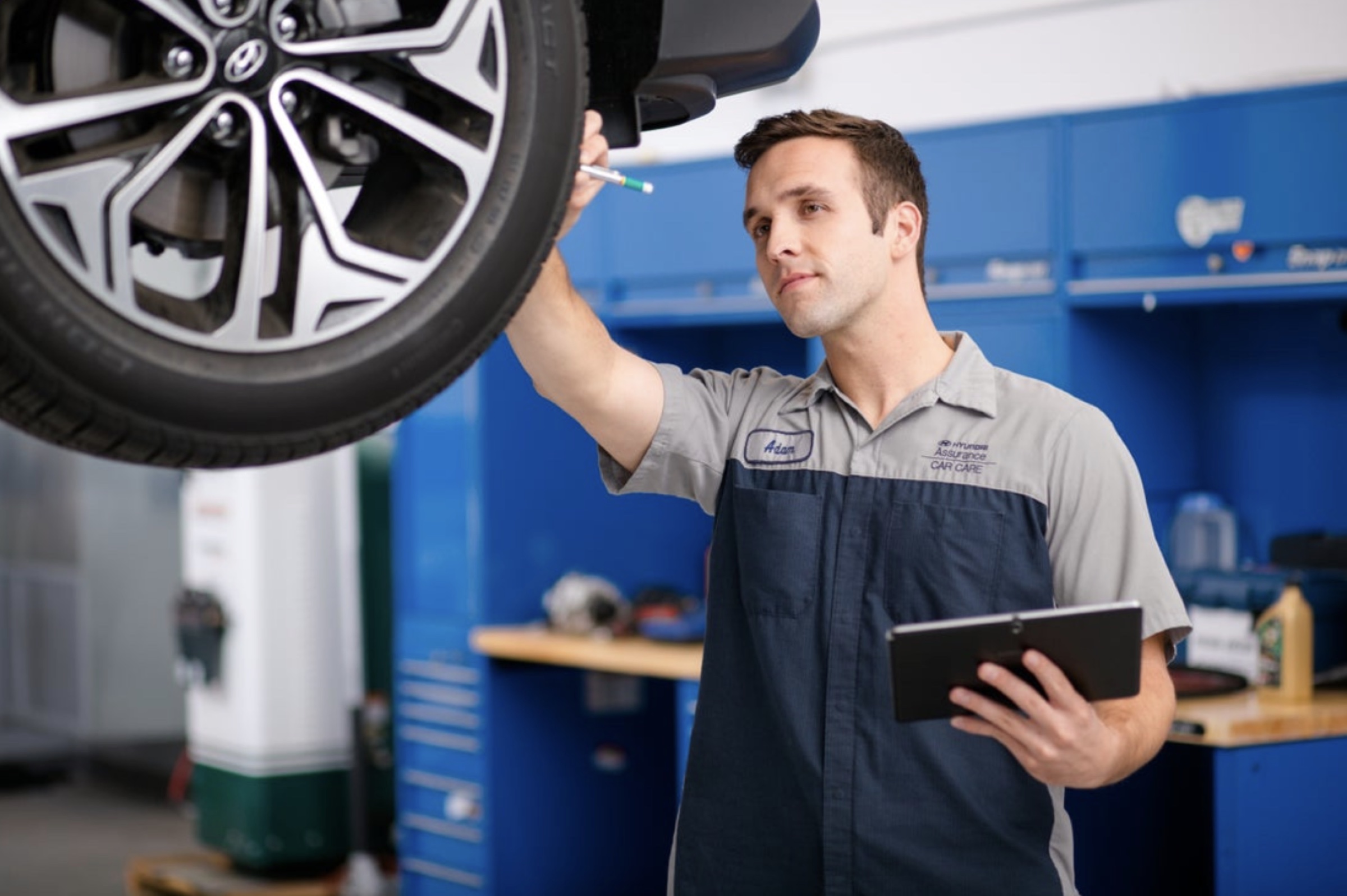 Hyundai technician servicing a vehicle wheel in the service bay