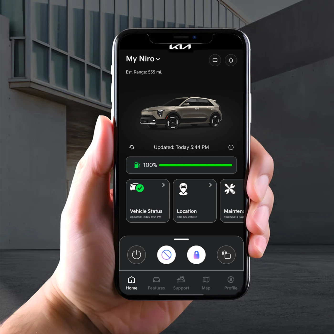 Hand holding a phone with the Kia Access app showing a 2027 Niro Hybrid