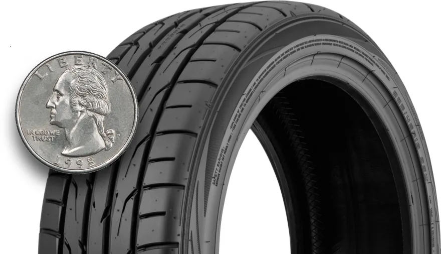 Quarter inserted into tire tread groove to check remaining tread depth