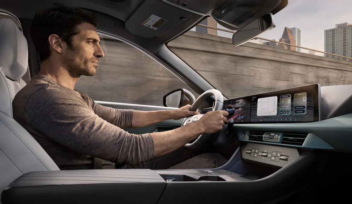Driver in the 2027 Nissan Rogue Hybrid cabin, hands on the steering wheel in city traffic.