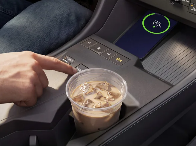 Driver using the center console controls in the 2027 Nissan Rogue Hybrid.