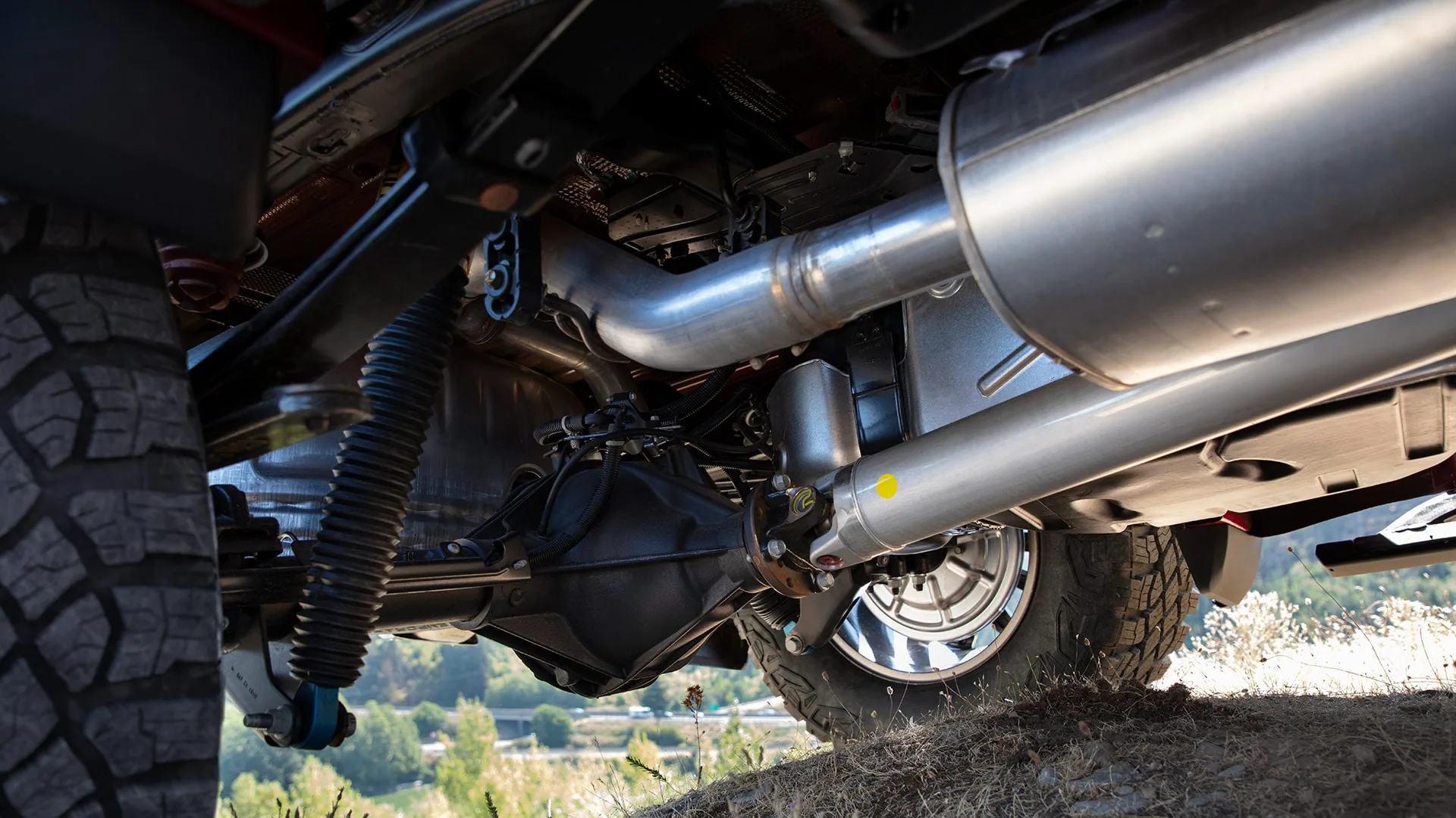 Undercarriage view of a GMC Sierra 1500 showing the rear suspension, differential, and exhaust