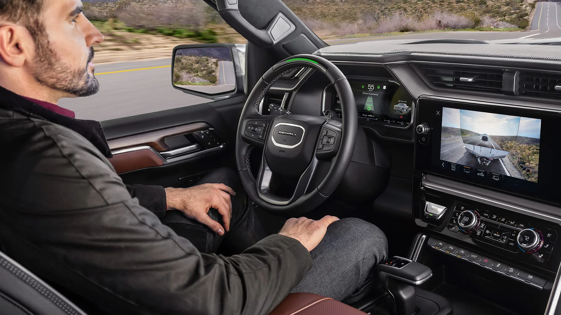 Profile view of a driver using Super Cruise hands-free driving with hands off the steering wheel in a GMC Sierra 1500