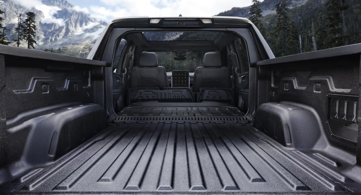 Interior view of a GMC Sierra EV showing the MultiPro Midgate open to the cargo bed