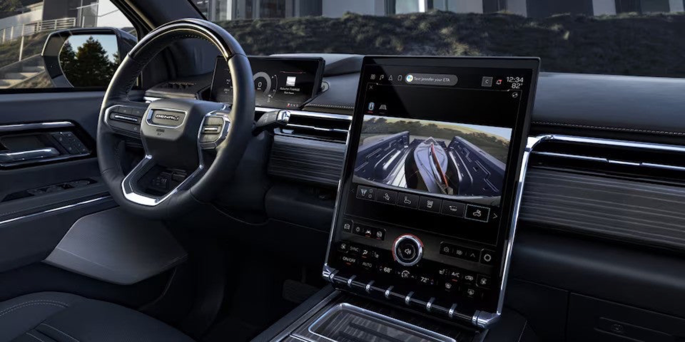Interior view of the GMC Sierra EV Denali steering wheel and infotainment system with the truck bed camera on screen