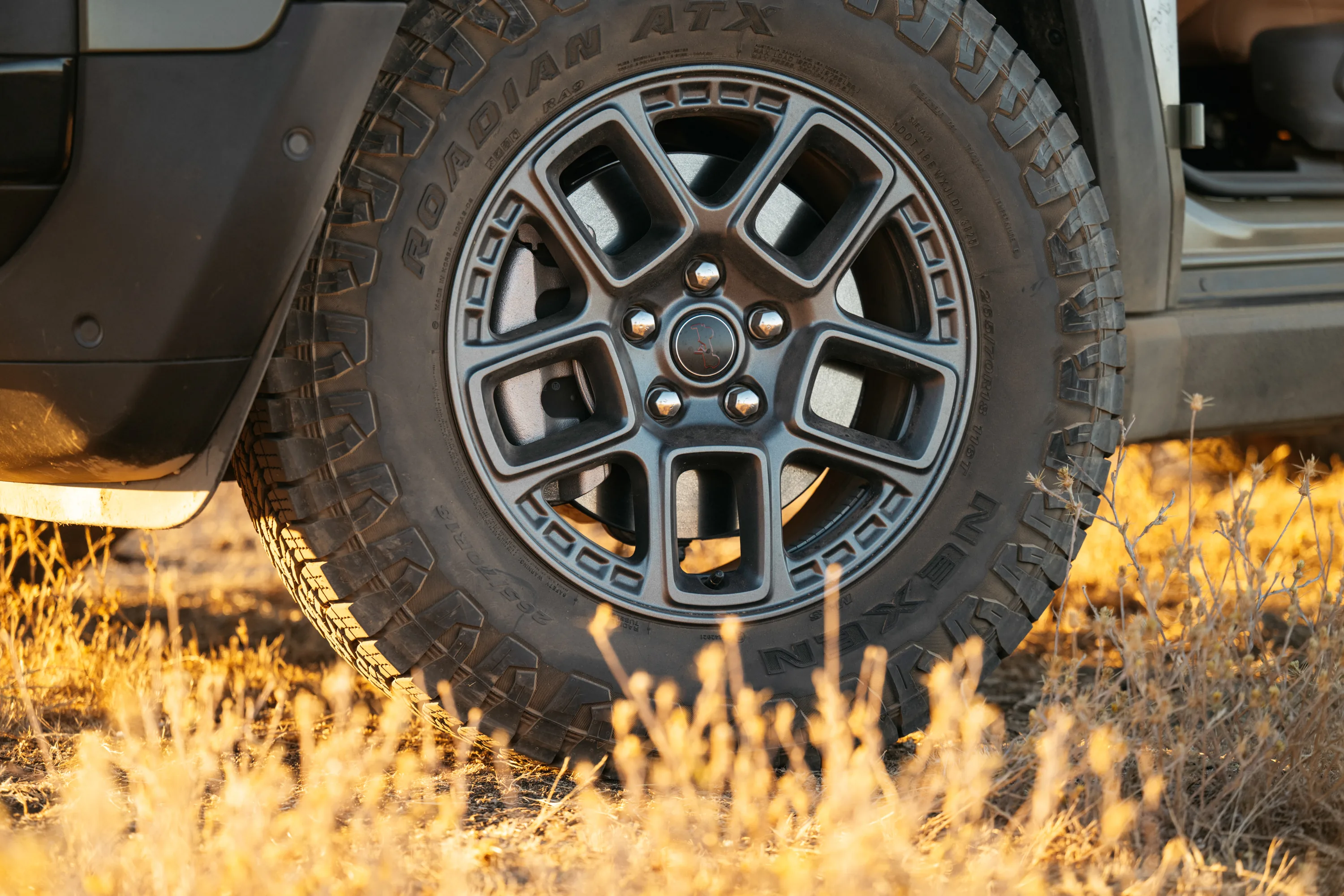 Jeep Brand technician performing maintenance on a Jeep vehicle tire and suspension